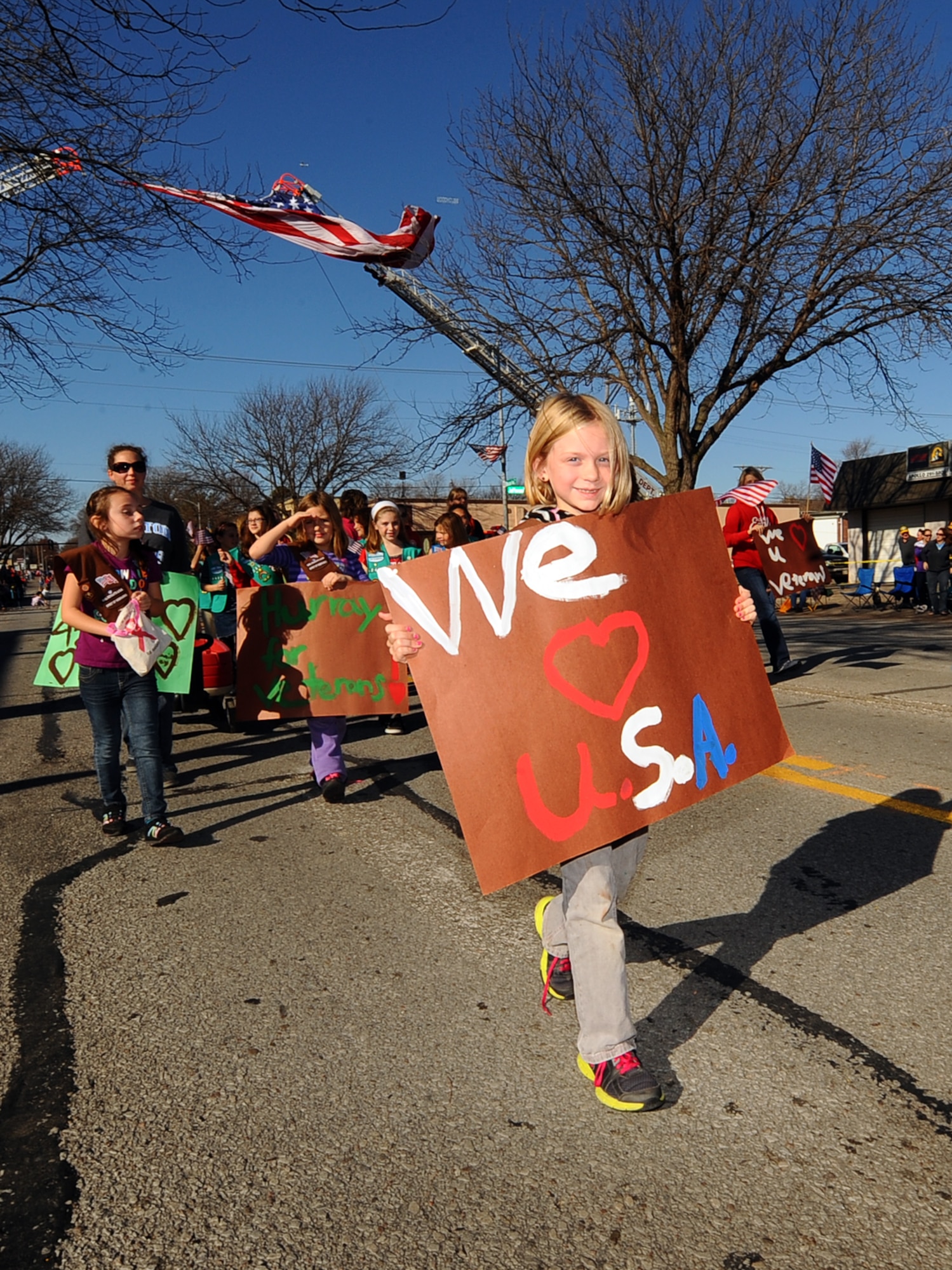 Erica Nickisch, with the Girl Scouts of America, shows her patriotism as she marches down Mission Avenue in the Veterans Day Parade in Bellevue, Neb., Nov. 10.  The parade consisted of several metro area businesses, schools, clubs and other organizations.  (U.S. Air Force photo by Josh Plueger/Released)