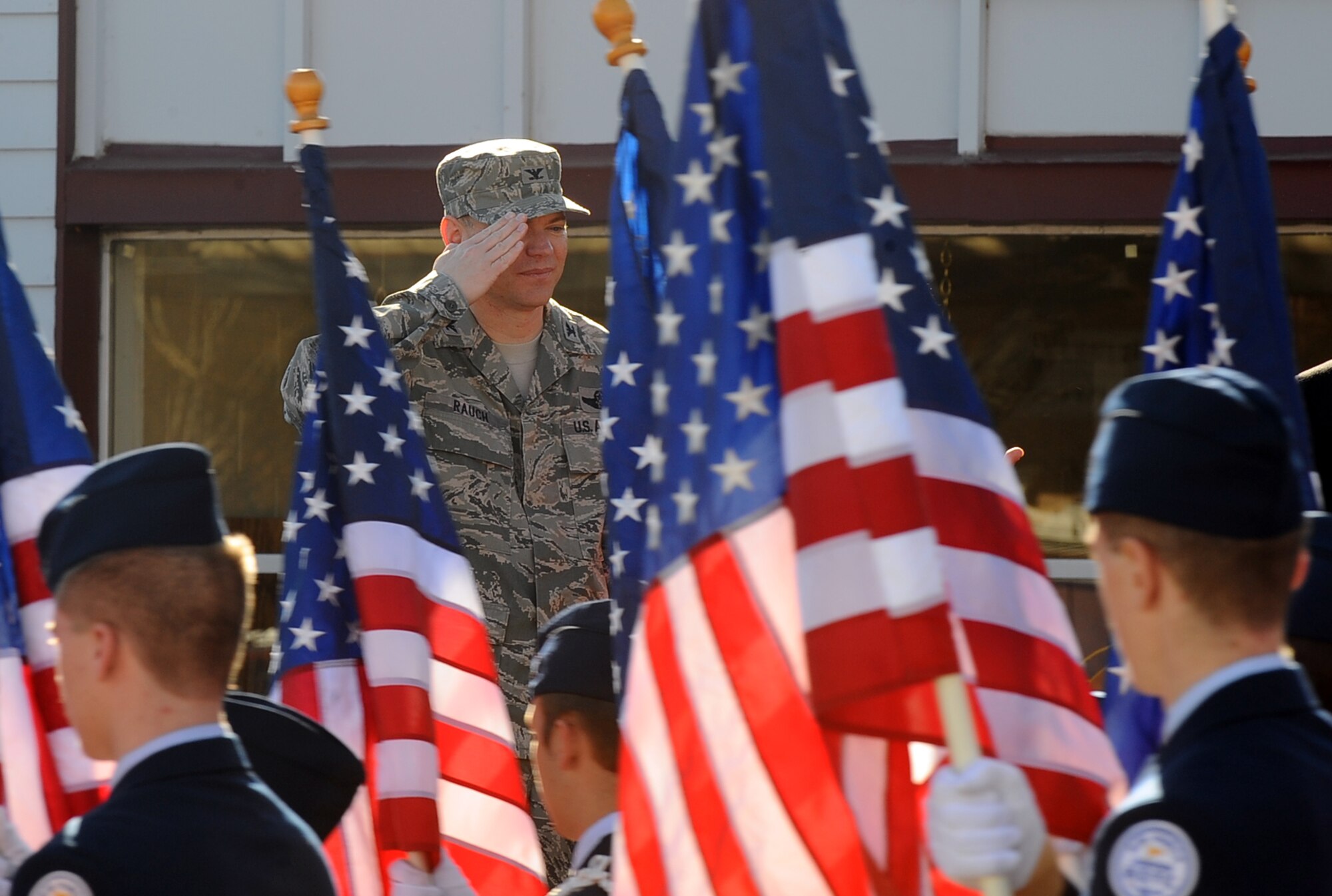 U.S. Air Force Col. John Rauch, 55th Wing commander, salutes the U.S. flags as they pass by on Mission Avenue while attending the annual Veterans Day parade in Bellevue, Neb., Nov. 10.  Team Offutt leadership stood on the grandstands at show central as the parade passed by.  (U.S. Air Force photo by Josh Plueger/Released)