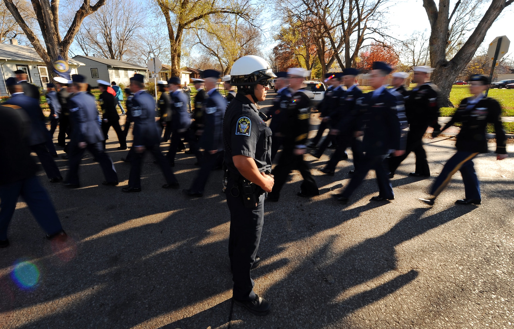 Bellevue, Neb. Police Officer Marcos Lopez, blocks residential traffic as the men and women from the 55th Wing and tenant units march toward the Veterans Day Parade held annually on Mission Avenue of Bellevue, Nov. 10.  Hundreds of people line the street for the parade every year.  (U.S. Air Force photo by Josh Plueger/Released)