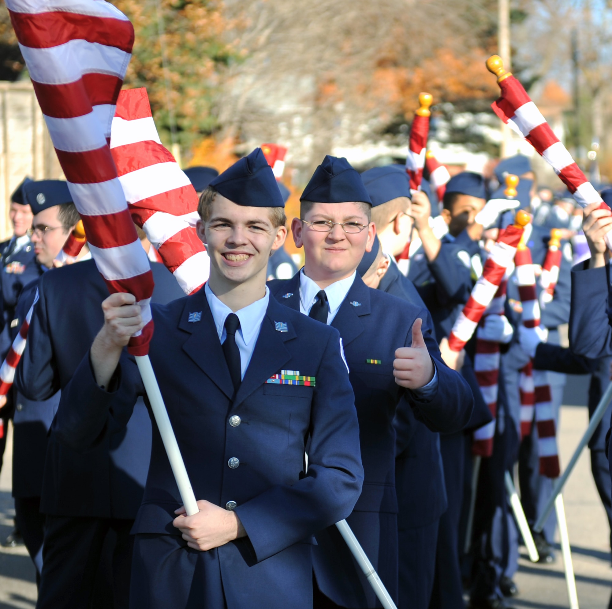 Daniel Smith smiles as Cameron Cattano gives a thumbs-up for the Bellevue East Junior ROTC at the 2012 Veterans Day parade in Bellevue, Neb. Nov. 10. The 55th Wing, U.S. Strategic Command, the Air Force Weather Agency and other base units joined with members of the Bellevue community to honor veterans at this annual parade. (U.S. Air Force photo by Jeff W. Gates/Released)