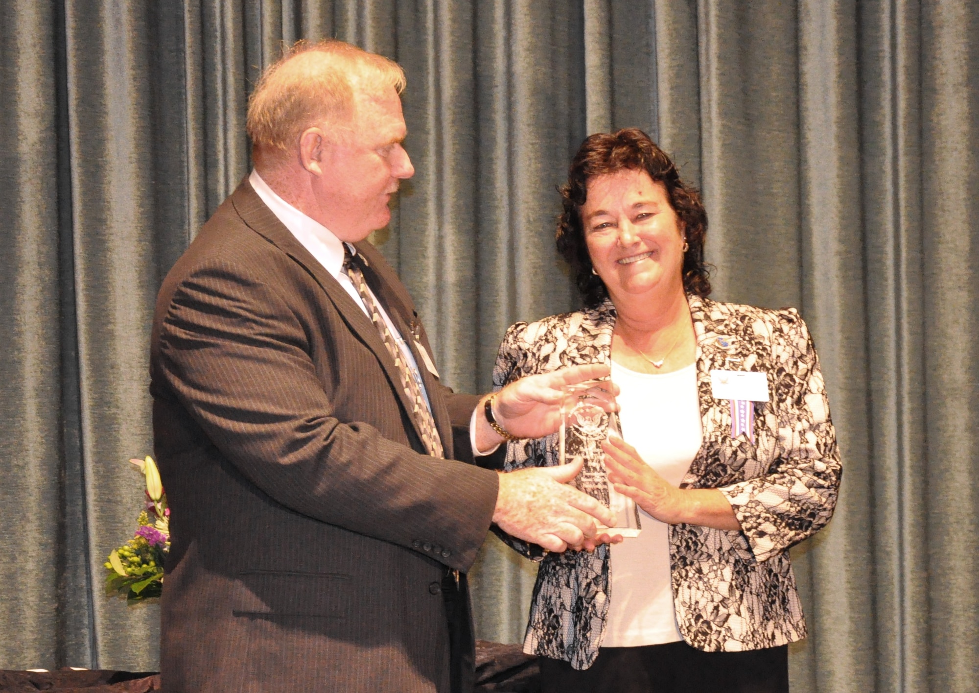 Jim McCarthy, chairman, National Space Club Florida Committee, awards Emily Perry, curator of the Air Force Space and Missile Museum, the 2012 Harry Kolcum News and Communications Award. 