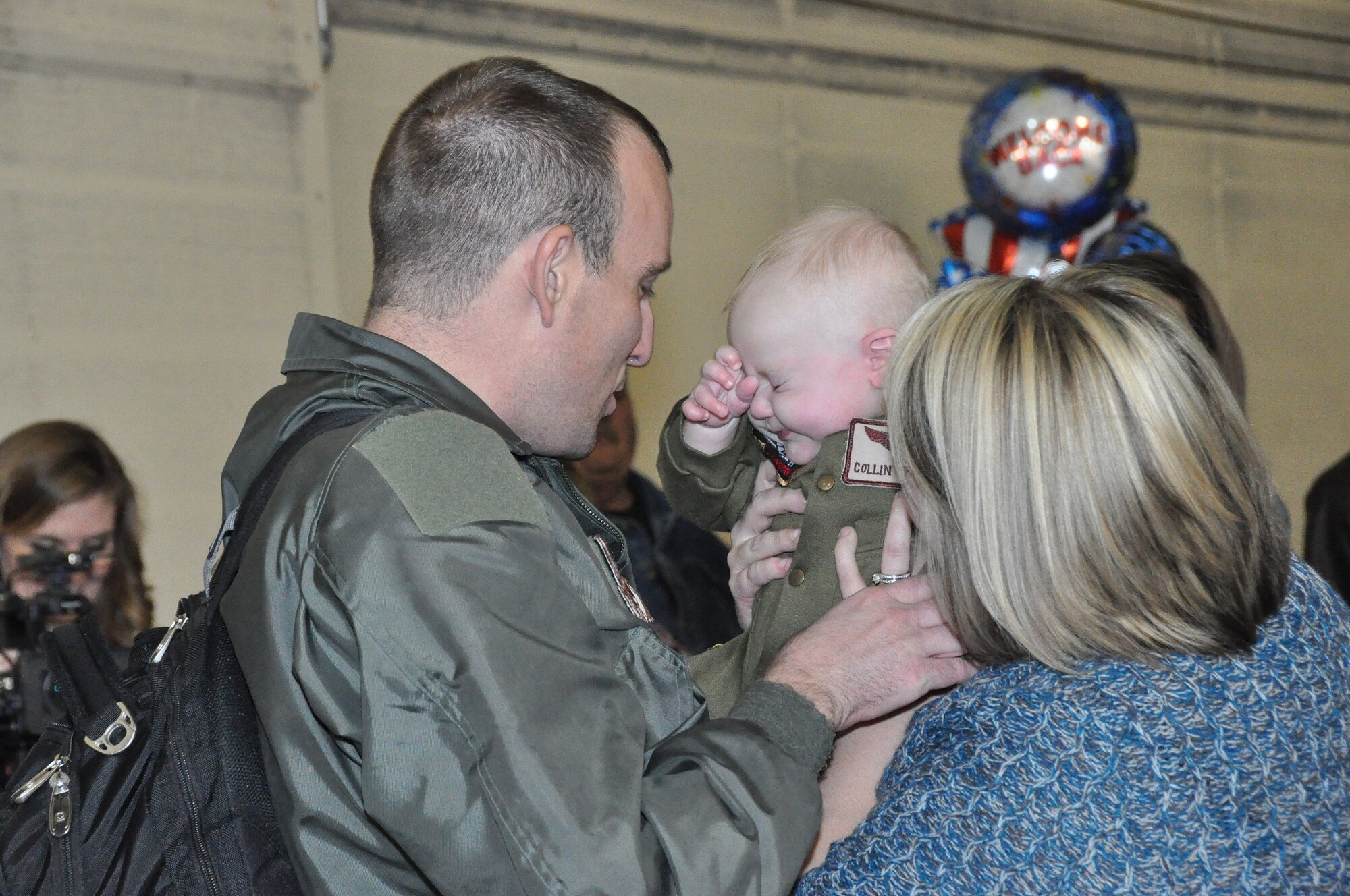 Master Sgt. Gabriel Richardson, an Air Surveillance Technician assigned to the 970th Airborne Air Control Squadron, holds his 6-month-old son for the first time. Richardson returned Sunday with 89 Reservists from the 513th Air Control Group after a 6-month deployment to Southwest Asia. Collin Richardson was born just a few days after Master Sgt. Richardson left on the deployment. (U.S. Air Force Photo byTech. Sgt. Sandra Hatton)