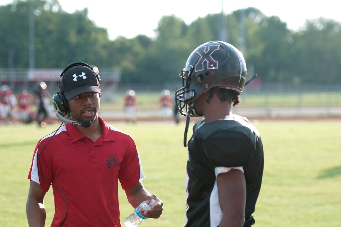 Kentucky Air National Guard Staff Sgt. Victor Cole, a maintenance analyst for the 123rd Maintenance Operations Flight, talks to one of his players during a Kentucky Xtreme football game in Jeffersonville, Ind., on July 28, 2012.  Cole is majority owner, general manager and coach for the Kentucky Xtreme outdoor football team, a minor league squad based in Louisville, Ky. (Kentucky Air National Guard photo by Master Sgt. Phil Speck)