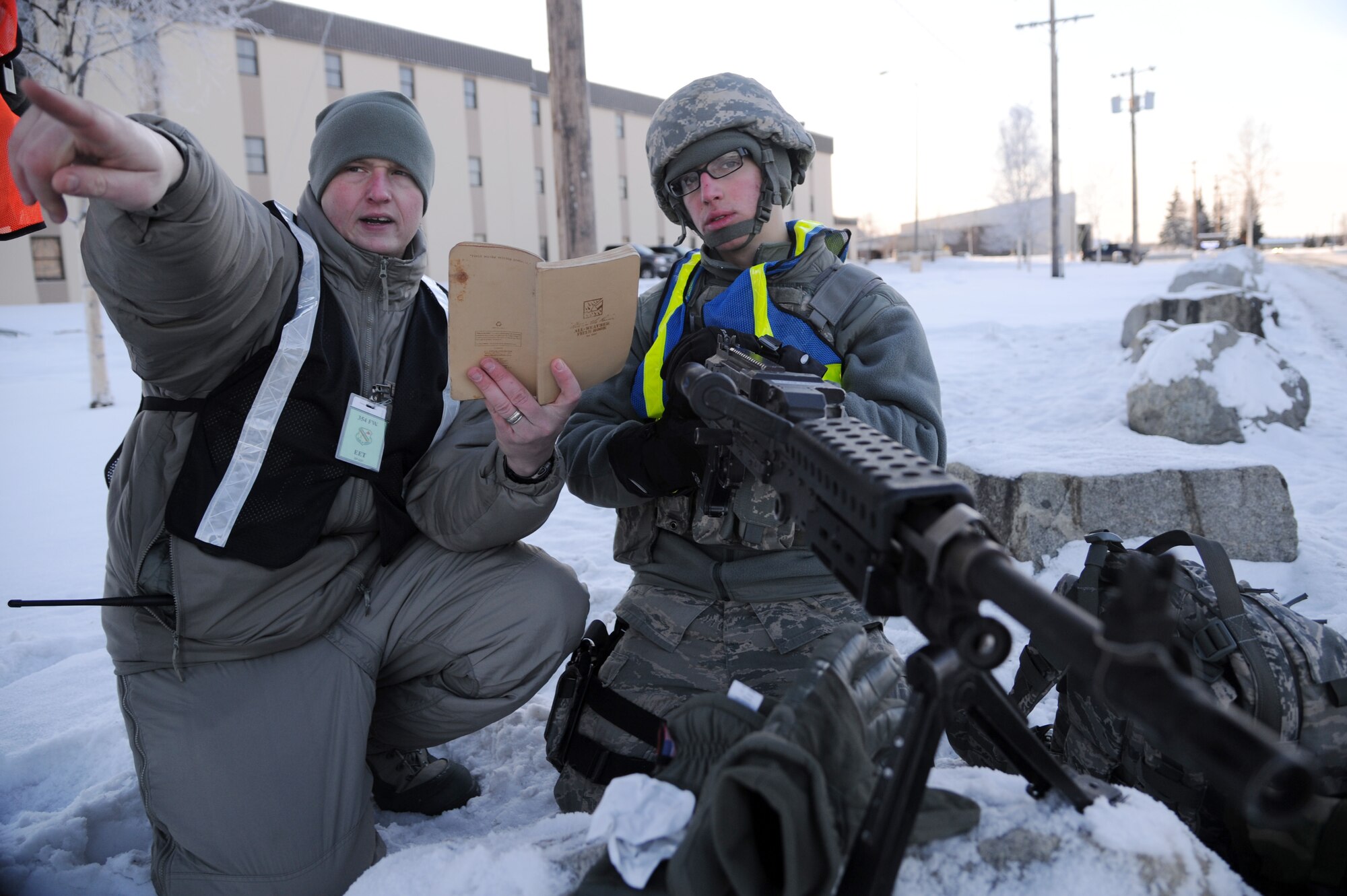 U.S Air Force Staff Sgt. Matthew Carr, 354th Security Forces Squadron electronic security systems NCO in charge, instructs the use of the 240B machine gun to Airman 1st Class Nicholas Garcia, 354th SFS entry controller, during an operational readiness exercise Nov. 8, 2012, Eielson Air Force Base, Alaska. As an exercise evaluation team member, Carr helps create a realistic exercise scenario to enhance the training environment for Icemen. (U.S. Air Force photo/Staff Sgt. Jim Araos)