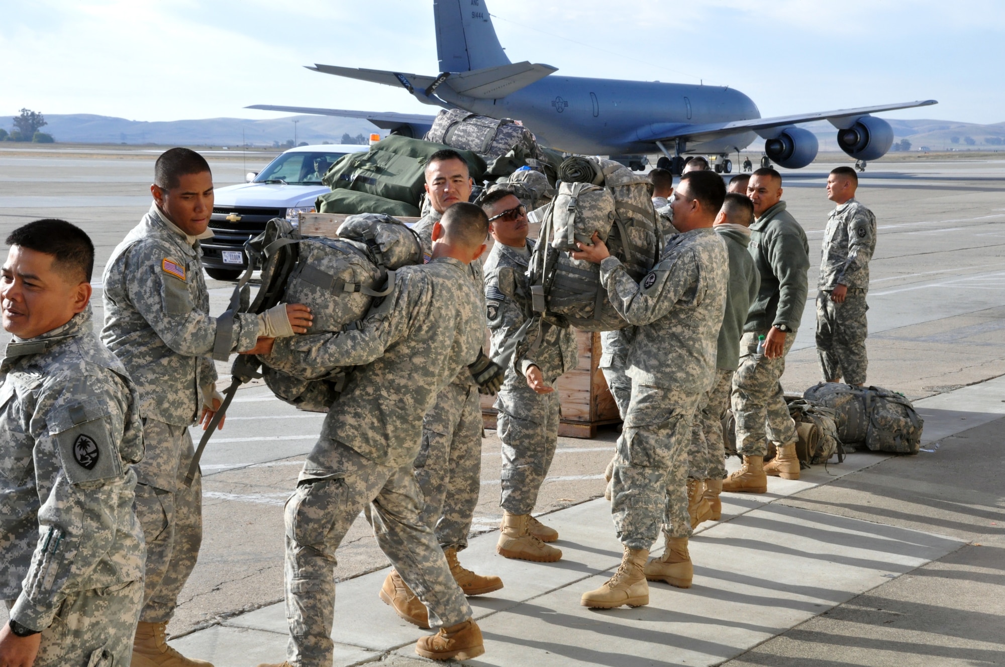 Soldiers from the 1-294th Infantry Regiment, Guam Army National Guard, work together to load their bags onto a pallet behind the Travis passenger terminal Wednesday. The Soldiers were passing through Travis to Guam after attending pre-mobilization training at Camp Roberts, Calif. (U.S. Air Force photo/Staff Sgt. Patrick Harrower)