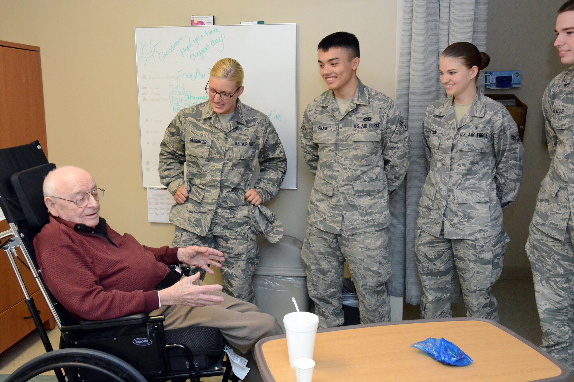 Airman Hannah Pierringer and Airmen 1st Class Cuong Pham, Brittany Guynn and Alexander Revels, 78th Air Base Wing, visit with WWII Army Veteran  Clarence Kunz, during the Veterans Day celebration at Carl Vinson VA Medical Center in Dublin Georgia.(U. S. Air Force photo/Ed Aspera)