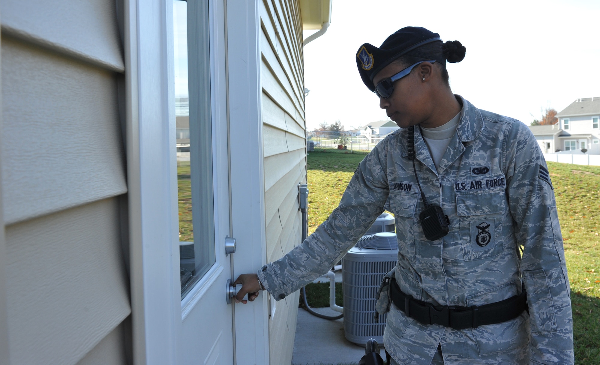 Senior Airman Keena Johnson, 509th Security Forces Squadron Law Enforcement, does an exterior check during her shift at Whiteman Air Force Base housing Nov. 13. As part of Operation Quarters Watch, the 509th SFS will physically check the resident's home to ensure all doors and windows are locked, secure, and that there is no damage. (U.S. Air Force photo/Heidi Hunt) (Released)