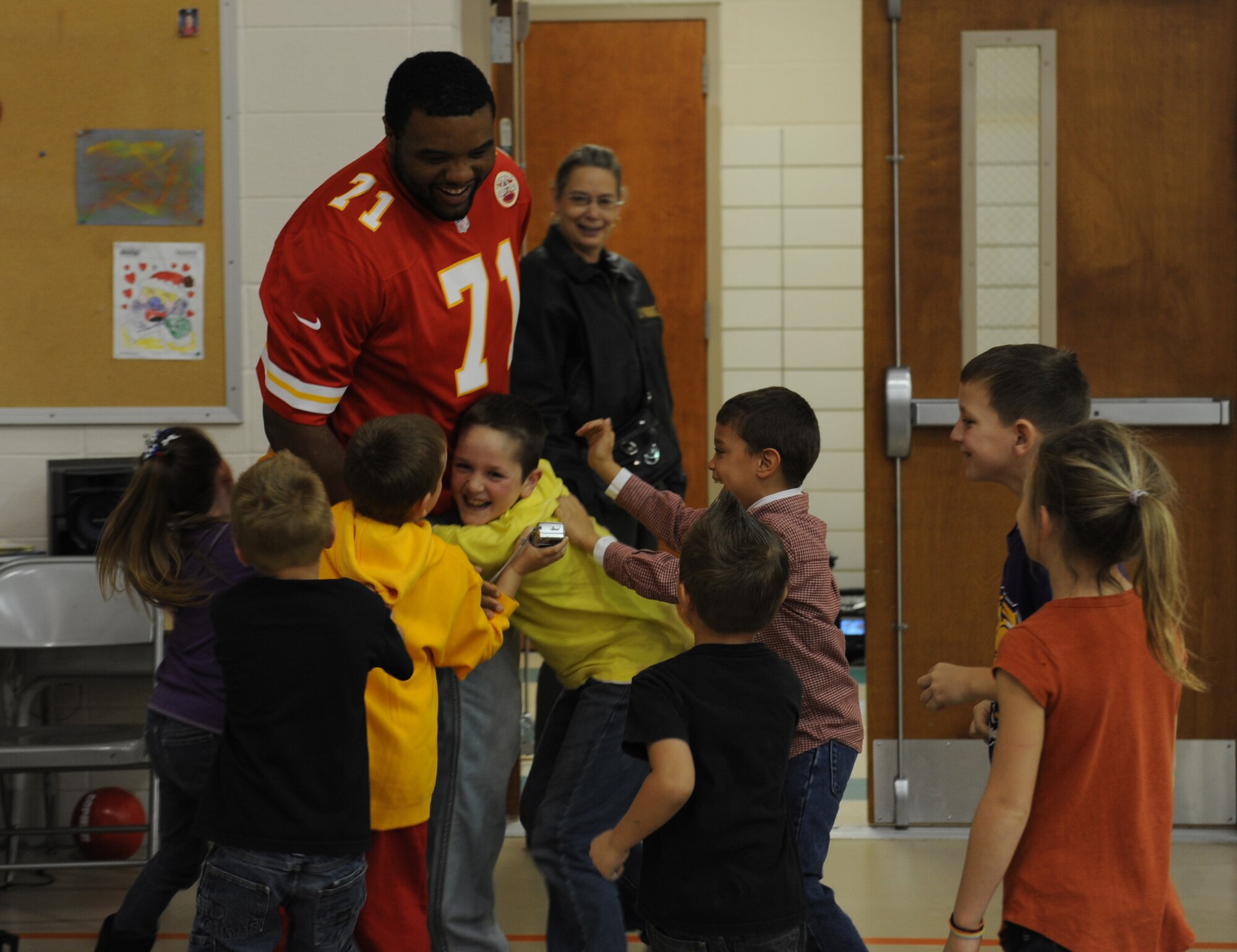 WHITEMAN AIR FORCE BASE -- Jeff Allen, Kansas City Chiefs offensive guard, is hugged by children at Whiteman Elementary School, Nov. 6. Members of the Kansas City Chiefs visited the school as part of the NFL’s Play 60 campaign, which encourages children to be active for 60 minutes a day in order to combat childhood obesity. (U.S. Air Force photo/Airman 1st Class Bryan Crane)
