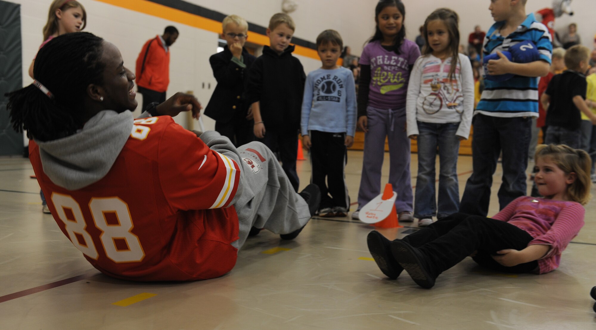 WHITEMAN AIR FORCE BASE -- Junior Hemingway, former Kansas City Chiefs wide receiver, does sit-ups with a child during the Play 60 event at Whiteman Elementary School, Nov. 6. Chiefs players also  toured Base Operations facilities and a B-2 Spirit. (U.S. Air Force photo/Airman 1st Class Bryan Crane)