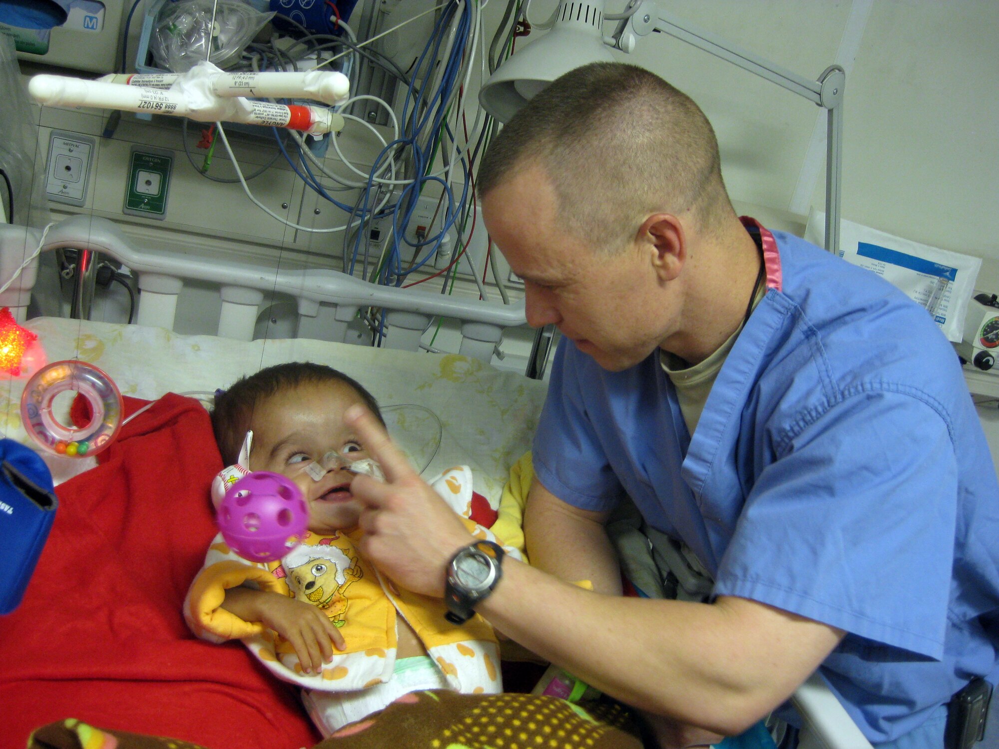 AFGHANISTAN  -- Dr. (Maj.) Christopher Wilhelm provides medical care for a 14-month old baby boy with hydrocephalus May 25 in Afghanistan. A buildup of cerebral spinal fluid putting pressure on the brain so severe the child couldn’t interact with his surroundings. After the procedure, the baby was able to perform normal child interactions. (Courtesy photo)