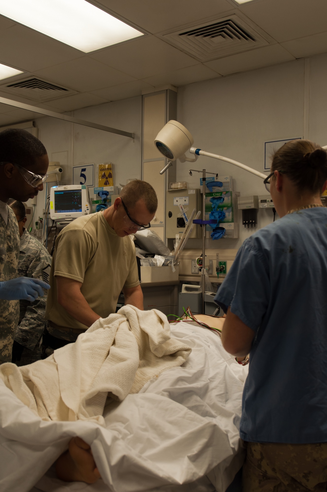 AFGHANISTAN  -- Dr. (Maj). Christopher Wilhelm provides medical care for a severely injured U.S. service member May 9 in Afghanistan. In addition to his pediatric duties, Wilhelm was also provided care to service members wounded in combat. (Courtesy photo)