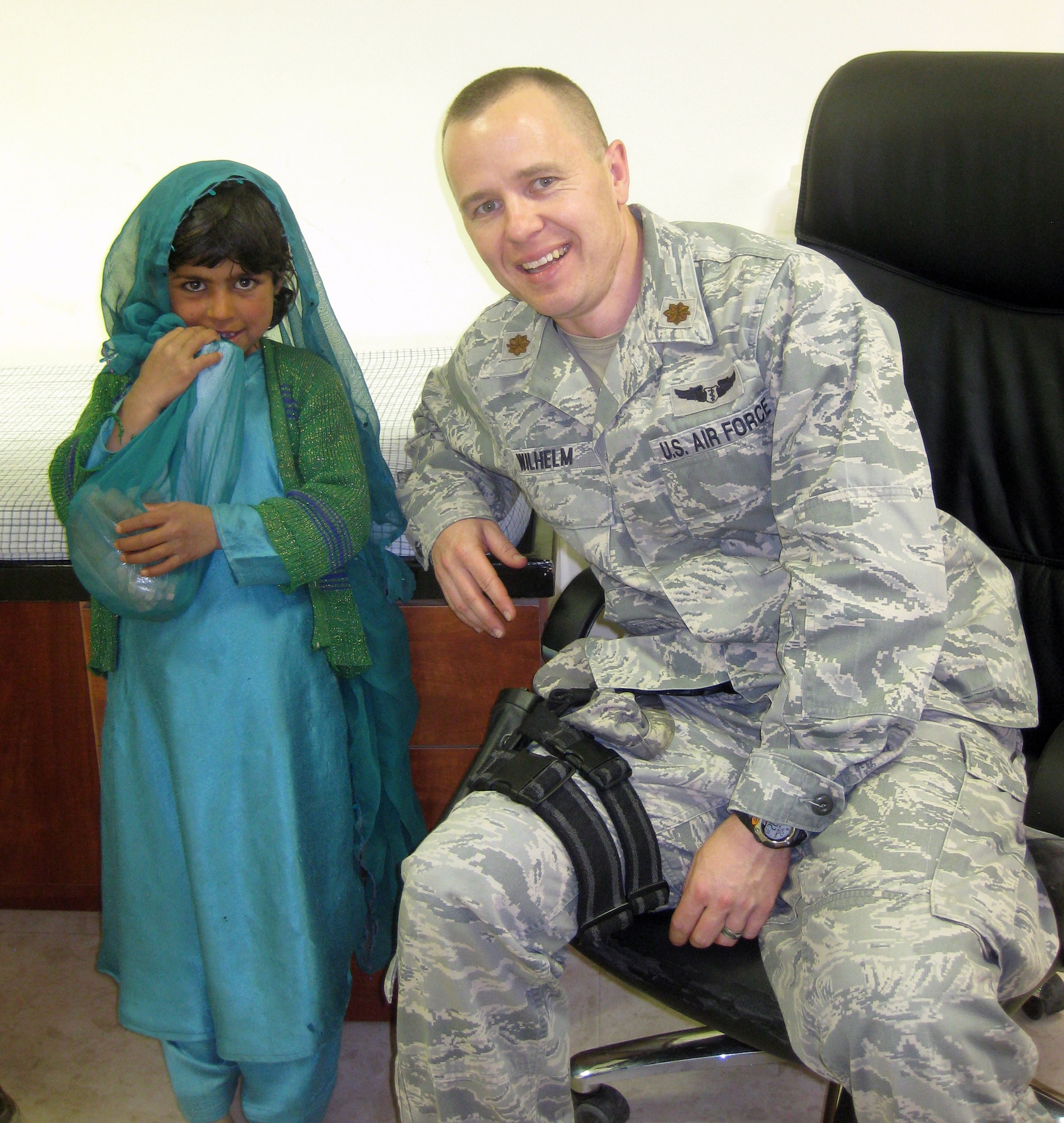 AFGHANISTAN  -- Dr. (Maj.) Christopher Wilhelm takes a photo with an 8-year-old girl he cared for during his deployment to Afghanistan April 2. Maj. Wilhelm was deployed from December 2011 to June 2012. (Courtesy photo)