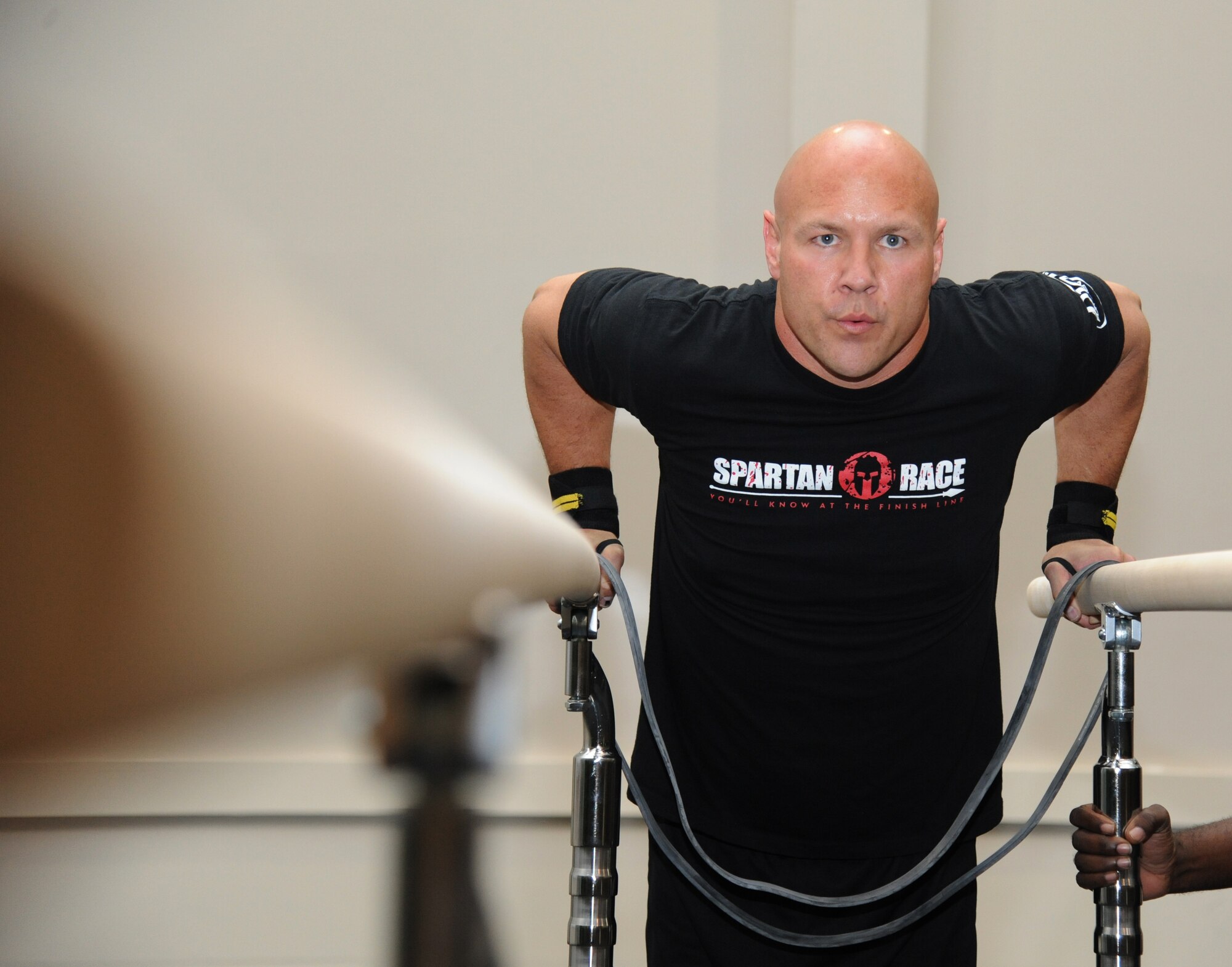 Master Sgt. Ed Scherzer, 53rd Weather Reconnaissance Squadron, performs a demonstration on the dip bar during the grand opening ceremony for the Warfighter Fitness Court Nov. 14, 2012, at the Dragon Fitness Center, Keesler Air Force Base, Miss.  The Warfighter Fitness Court provides fitness enthusiasts with a new alternative to traditional fitness training that is fully customizable for any experience level and designed to enhance strength and conditioning.  (U.S. Air Force photo by Kemberly Groue)