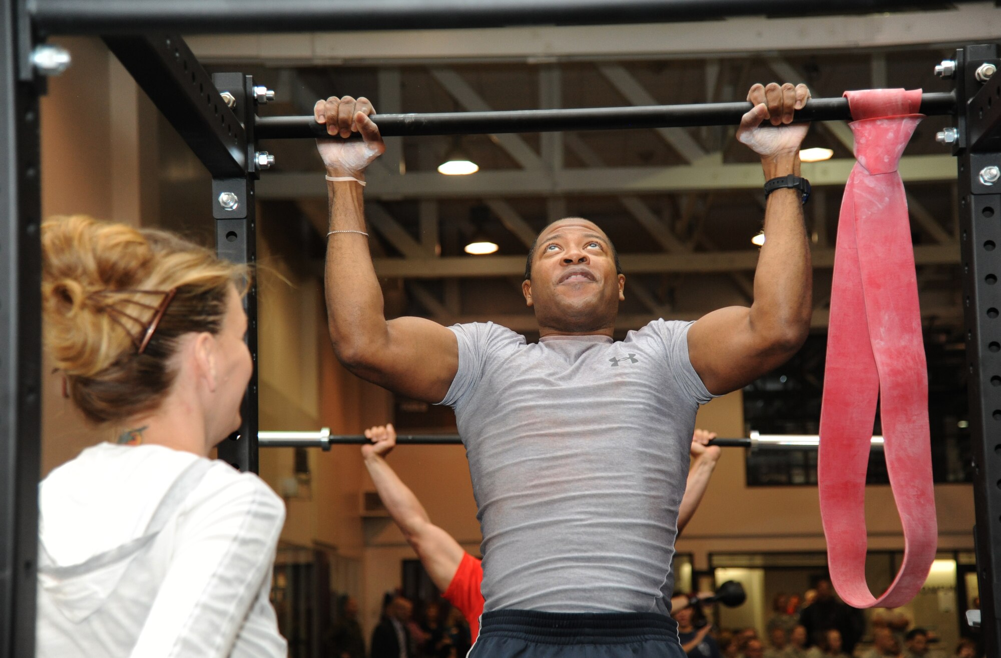 Janel Ward, CSC fitness specialist, assists Tech. Sgt. Michael Wright, 333rd Training Squadron, as he performs a demonstration on a pull up bar during the grand opening ceremony for the Warfighter Fitness Court Nov. 14, 2012, at the Dragon Fitness Center, Keesler Air Force Base, Miss.  The Warfighter Fitness Court provides fitness enthusiasts with a new alternative to traditional fitness training that is fully customizable for any experience level and designed to enhance strength and conditioning.  (U.S. Air Force photo by Kemberly Groue)
