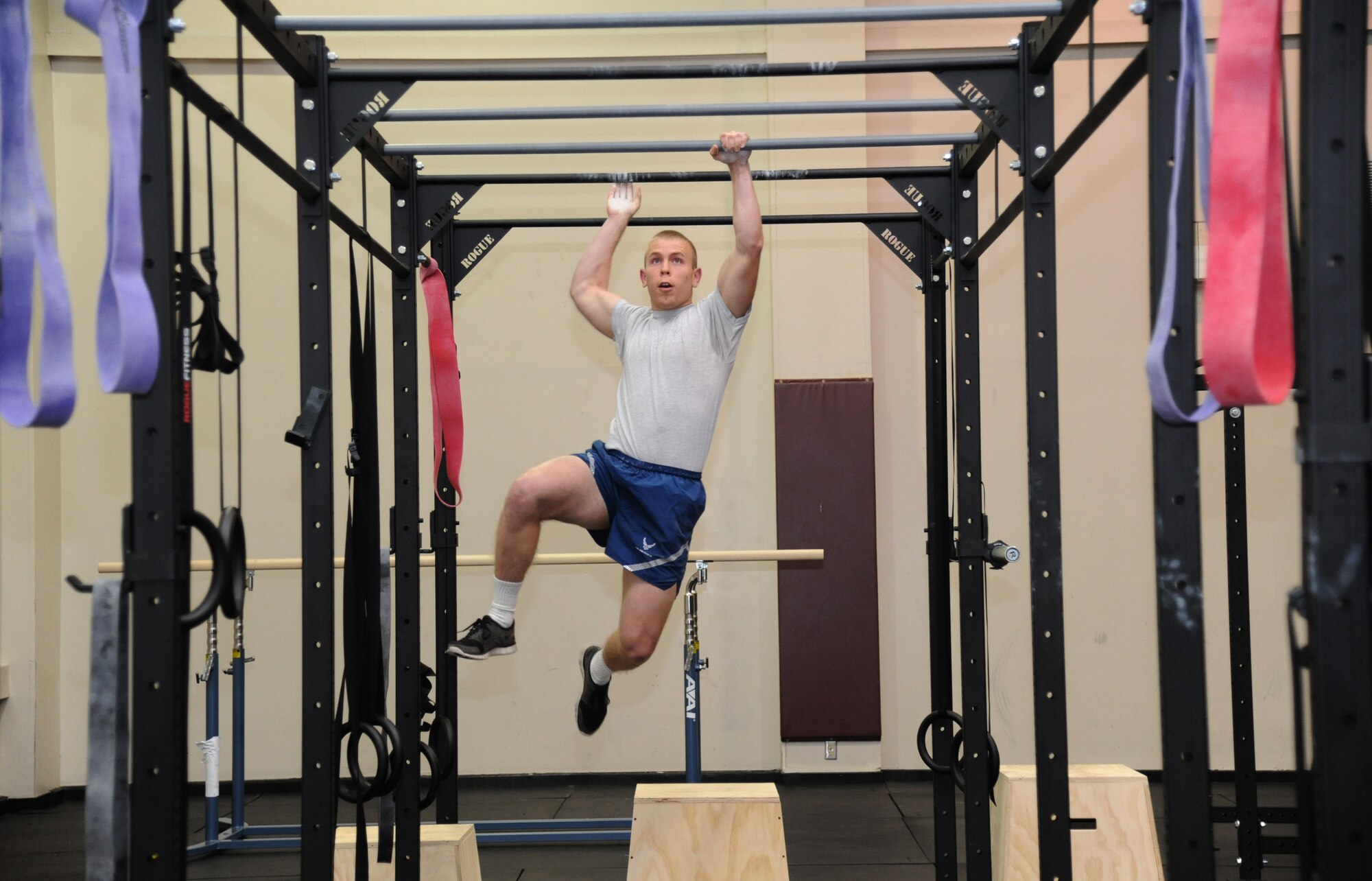 Airman 1st Class Travis McAdams, 81st Diagnostic and Therapeutics Squadron, performs a demonstration on the monkey bars during the grand opening ceremony for the Warfighter Fitness Court Nov. 14, 2012, at the Dragon Fitness Center, Keesler Air Force Base, Miss.  The Warfighter Fitness Court provides fitness enthusiasts with a new alternative to traditional fitness training that is fully customizable for any experience level and designed to enhance strength and conditioning.  (U.S. Air Force photo by Kemberly Groue)