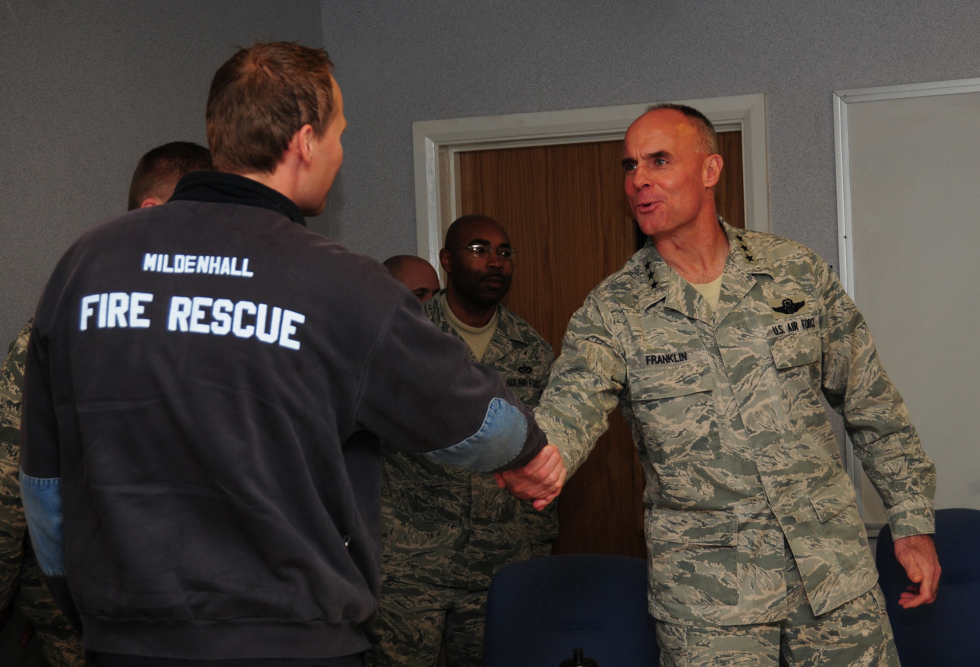 Lt. Gen. Craig A. Franklin, 3rd Air Force commander, Ramstein Air Base, Germany, coins Firefighter Simon Law, 100th Civil Engineer Squadron Fire Department Nov. 15, 2012,at RAF Mildenhall, England. Franklin recognized Law for his win as Civilian of the Quarter for 100th CES, 100th Air Refueling Wing and Team Mildenhall. While here, Franklin met with base leadership and Airmen at a breakfast, briefings and lunch. While in England, the general also visited RAF Fairford, RAF Croughton, RAF Welford, RAF Lakenheath and the Cambridge American Cemetery at Madingley. (U.S. Air Force photo by Karen Abeyasekere/Released)