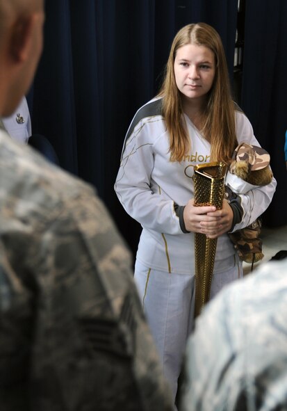Bailey Reese holds her Olympic torch and Hero the bear as she speaks with members of the U.S. Air Force Honor Guard at Joint Base Anacostia-Bolling, D.C., Oct. 24.  Bailey is the president and founder of Hero Hugs, a non-profit organization that sends care packages to service members overseas.  (U.S. Air Force photo/Staff Sgt. Torey Griffith)