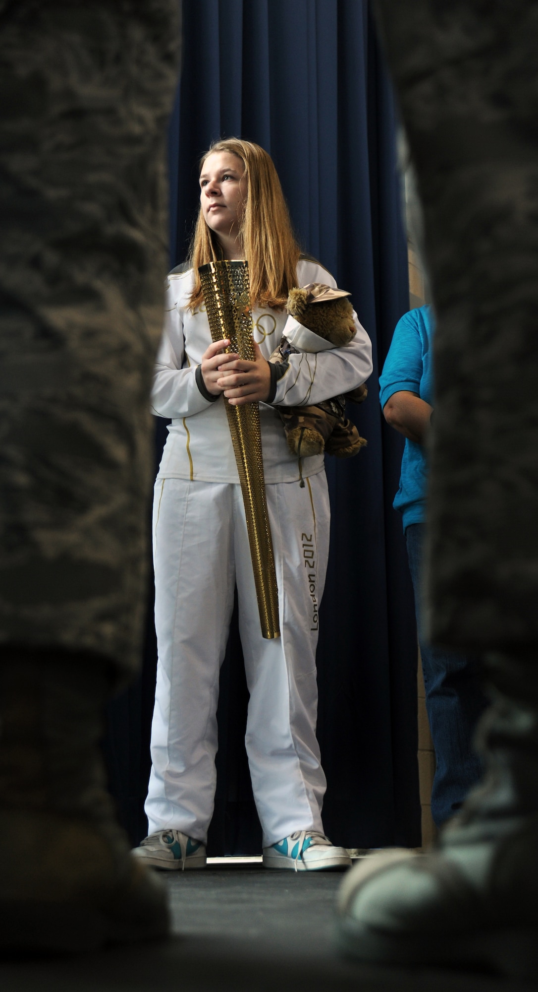 Bailey Reese holds her Olympic torch and Hero the bear as she speaks with members of the U.S. Air Force Honor Guard at Joint Base Anacostia-Bolling, D.C., Oct. 24.  Bailey is the president and founder of Hero Hugs, a non-profit organization that sends care packages to service members overseas.  (U.S. Air Force photo/Staff Sgt. Torey Griffith)