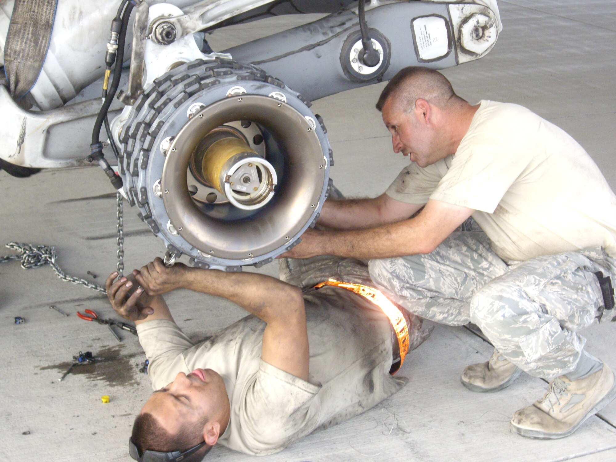 Staff Sgt. Alan Soriano (left) connects a brake temperature sensor harness cannon plug to the brake temperature sensor while Tech. Sgt. Gregory Bernett attaches hardware related to the brake assembly and harnesses Sept. 14, 2012. Soriano and Bernett are a part of a seven-man mission recovery team assigned to the 8th Expeditionary Air Mobility Squadron who forward deployed to Forward Operating Base Shank, Afghanistan, to recover a downed C-17 Globemaster III. The team, while under daily mortar attacks, replaced repair twelve tires, eight brakes and break temperature sensors on the immobile C-17 to get it flight ready. (U.S. Air Force courtesy photo)