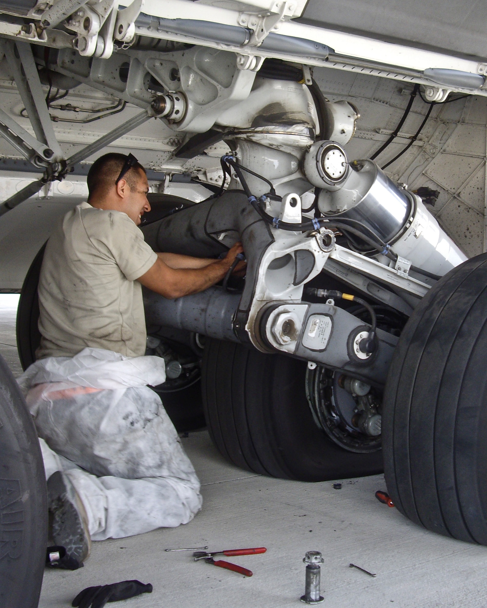 Staff Sgt. Alan Soriano, 8th Expeditionary Air Mobility Squadron mission recovery team member, routes the brake temperature sensor harness along the main landing gear bogie on a downed C-17 Globemaster III at Forward Operating Base Shank, Afghanistan Sept. 13, 2012. Soriano, along with six other team members, was forward deployed to repair twelve tires, eight brakes and break temperature sensors on a C-17 to get it air ready and protect the Air Force asset from daily mortar attacks. (U.S. Air Force courtesy photo)