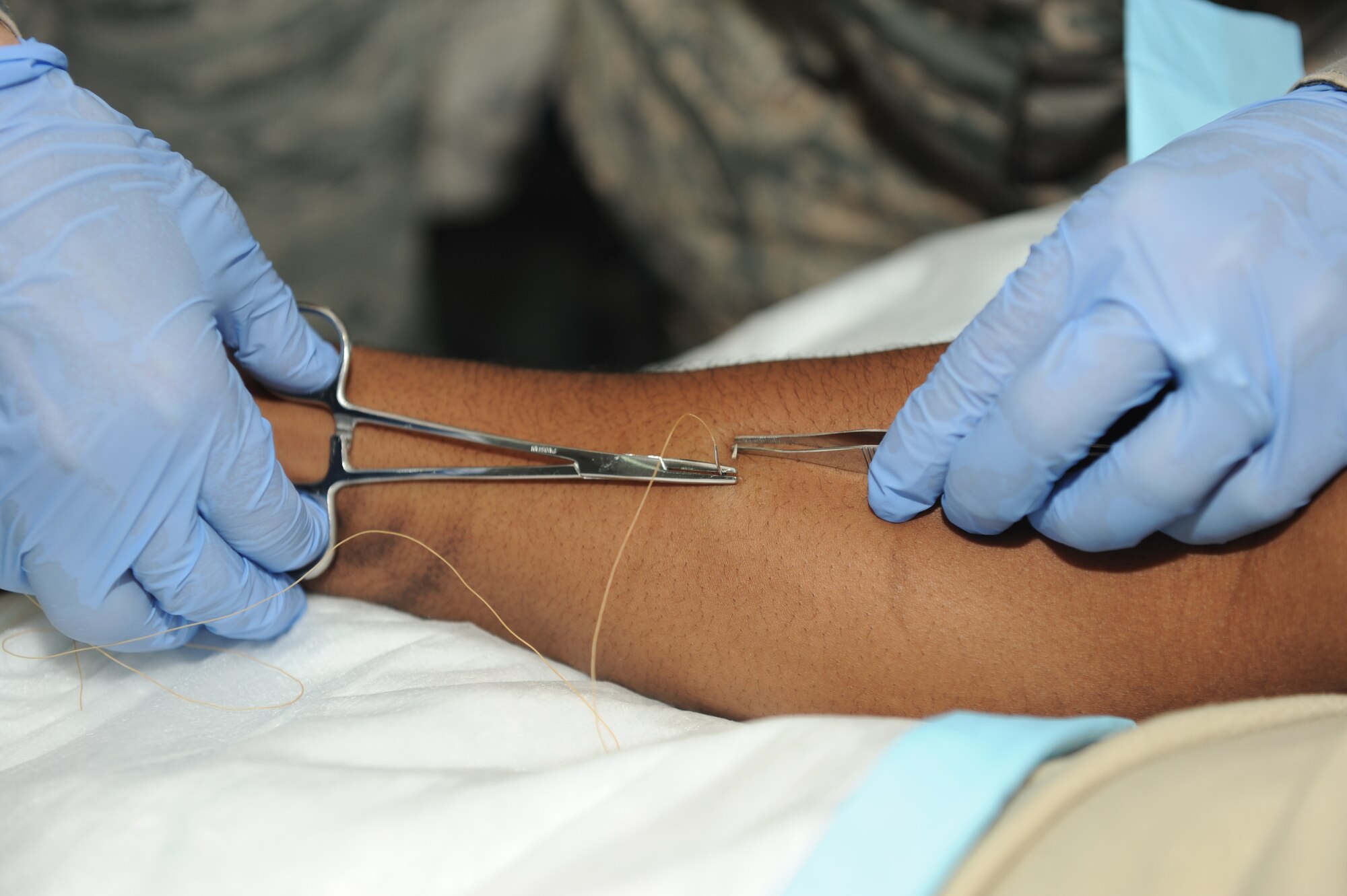 SOUTHWEST ASIA - Airman 1st Class Anthony Dean, 379th Expeditionary Medical Group combat medical technician, allows his arm to be sutured during a training exercise Nov. 14, 2012. Combat medics use one another as training aides to ensure they are at the top of their game and prepared for all real world situations. Combat medics are frequently forward deployed to forward operating bases where they are the only medical technician in the area. Dean is deployed from Joint Base Langley-Eustis, Va., and is a native of Virginia Beach, Va. (U.S. Air Force photo/Senior Airman Joel Mease)