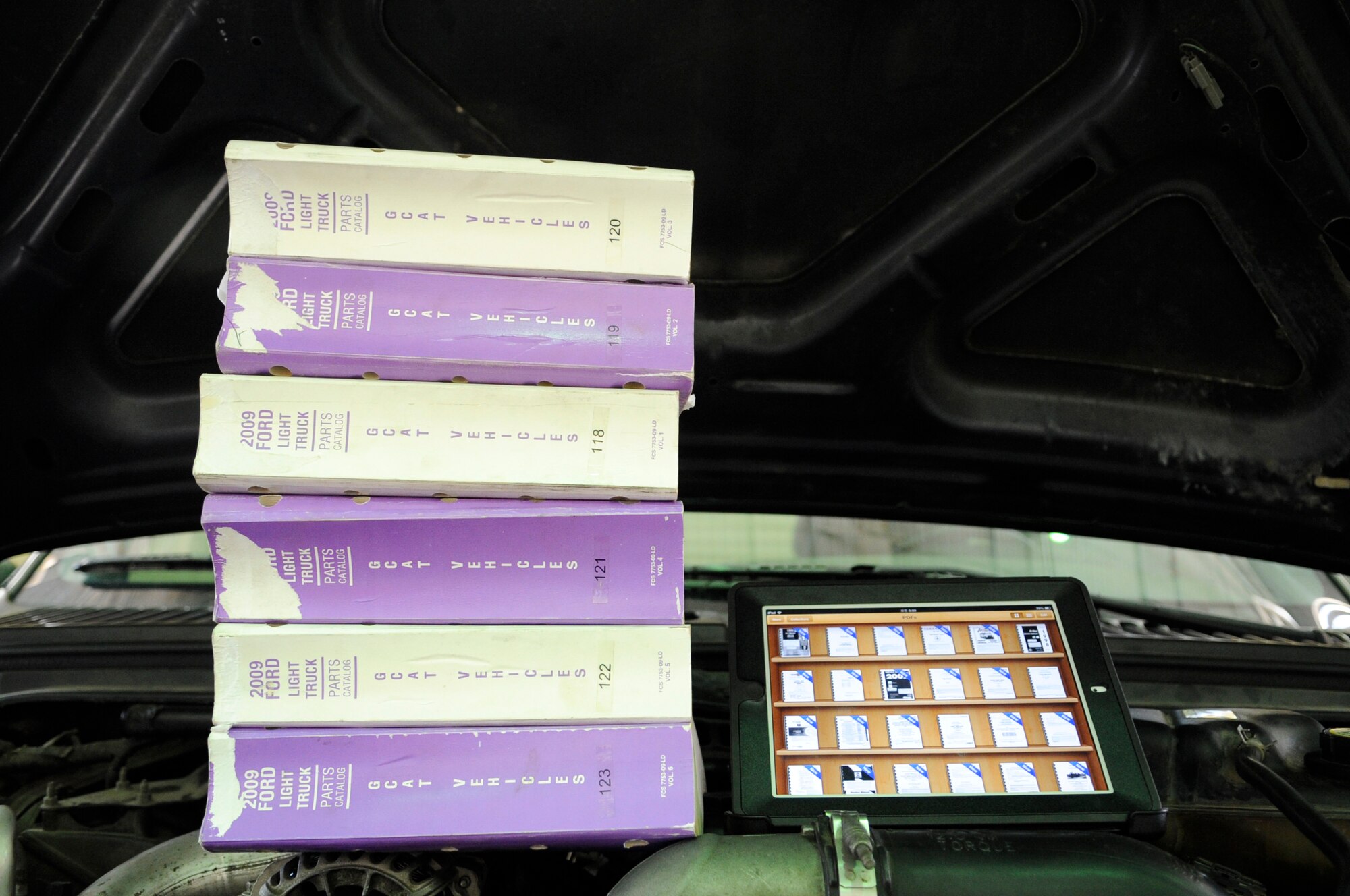 Six volumes of technical orders out of the hundreds mechanics must reference while troubleshooting is compared to an electronic tablet at Kunsan Air Base, Republic of Korea, Nov. 1, 2012. The 8th Logistics Readiness Squadron recently bought 19 tablets, each of which is already loaded with more than 625,000 pages of technical information that saves mechanics valuable time. (U.S. Air Force photo/Senior Airman Brigitte N. Brantley)