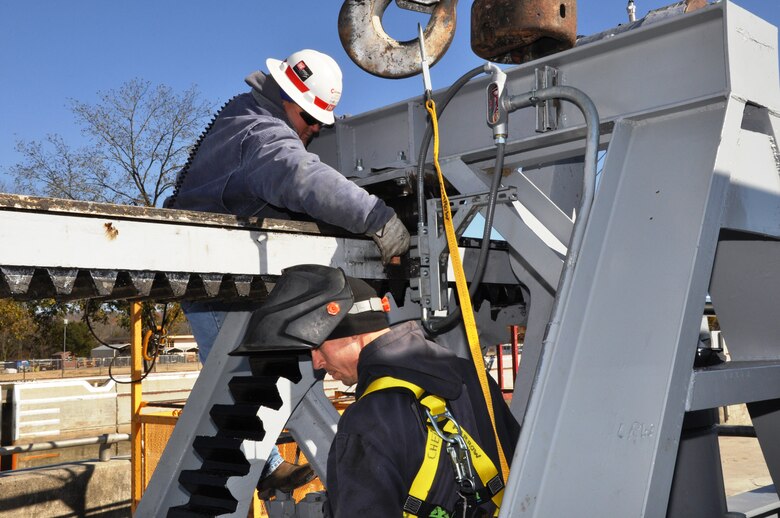 Carl Scott, above, supervisor, U.S. Army Corps of Engineers Nashville District, places a metal “flag” for the lower river wall valve limit that Terry Farrow, electrician, below, will weld at Cheatham Lock, Ashland City, Tenn., Nov. 13, 2012. Upper river valves fill the lock chamber to lake level and lower river valves lower it to tailwater level. (USACE photo by Fred Tucker)