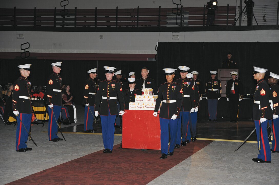 Marines escort a traditional birthday cake during the Marine Corps Birthday Ball at Darton State College, Nov. 8. They are flanked by Marines on sword detail. The cutting of the cake symbolizes the passing of experience from the oldest generation of Marines to the youngest. A slice of cake was also presented to the guest of honor.
