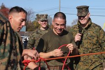 Sgt. Andrew Straehle (right), the commentator for the Chemical Biological Incident Response Force Commander’s Challenge, adds difficulty to the knot portion of the challenge for GySgt. John Schmuck and his team by administering a little banter while the Marines attempted to complete their knots. (Official Marine Corps photo by Sgt. Frances L Goch, Released)