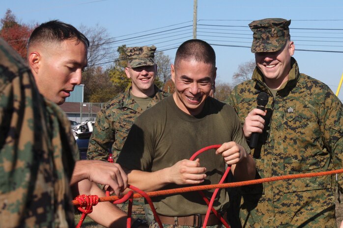 Sgt. Andrew Straehle (right), the commentator for the Chemical Biological Incident Response Force Commander’s Challenge, adds difficulty to the knot portion of the challenge for GySgt. John Schmuck and his team by administering a little banter while the Marines attempted to complete their knots. (Official Marine Corps photo by Sgt. Frances L Goch, Released)