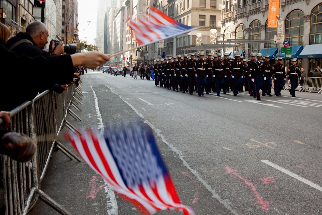 New Yorkers wave flags and cheer for Marines from 6th Communications Battalion, Marine Forces Reserve, as they marched in the annual New York Veterans Day parade, here, Nov. 11.  The parade is hosted by the United War Veterans Council, Inc. on behalf of the City of New York. It is the oldest and largest of its kind in the nation. Since November 11, 1919, the parade has provided an opportunity for Americans and International visitors to honor those who have served in the nation's largest city. (Official Marine Corps photo by Cpl. Bryan Nygaard)