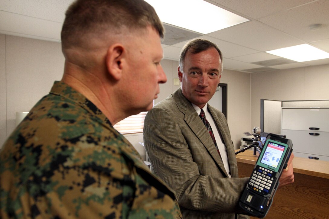 Mike Stefenyshyn, from the Base Access Control branch, gives Maj. Gen. James A. Kessler (center), commanding general of Marine Corps Installations Command and assistant deputy commandant of installations and logistics, a brief on the new hand-held scanners and Rapid Gate software that are being used at entry-points at Camp Pendleton Nov. 8.