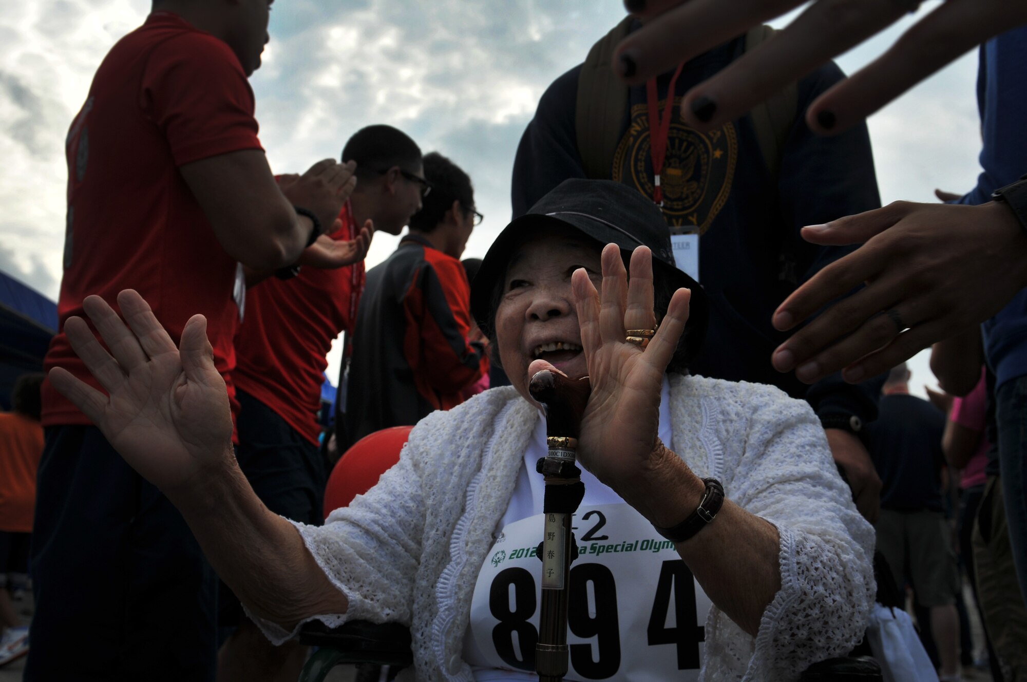Haruko Shimano, an athlete participating in the the 13th annual Kadena Special Olympics arrive as thousands of attendees cheer them on as part of the KSO opening ceremonies on Kadena Air Base, Japan, Nov. 17, 2012.  Kadena Special Olympics was established in 2000 by the 18th Wing commander as an avenue to build relations with neighboring communities and local government representatives while providing a meaningful activity for the special needs children and adults. (U.S. Air Force photo/Tech. Sgt. Jocelyn Rich)