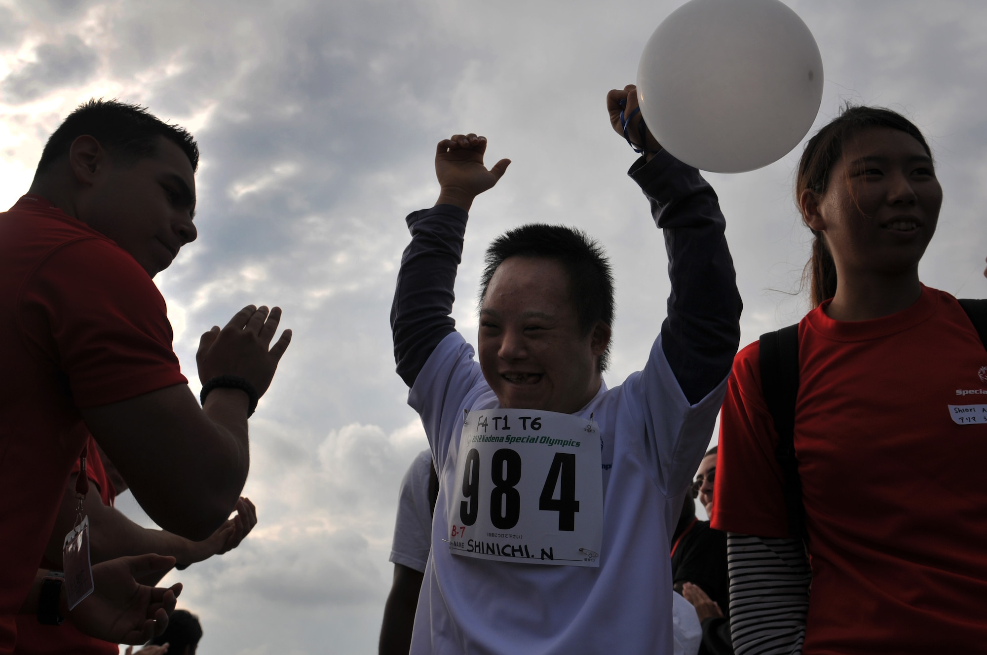 Shinichi Nakamura, an athlete participating in the the 13th annual Kadena Special Olympics arrive as thousands of attendees cheer them on as part of the KSO opening ceremonies on Kadena Air Base, Japan, Nov. 17, 2012.  More than 1,500 artists and athletes participated in a variety of events ranging from 200 and 300 meter races, tennis skills and floor hockey to soccer skills and ground golf during the 13th Annual KSO. This year marks the 13th Annual KSO, a sporting event dedicated to enriching the lives of special-needs individuals while strengthening U.S. - Okinawa relationships. (U.S. Air Force photo/Tech. Sgt. Jocelyn Rich)