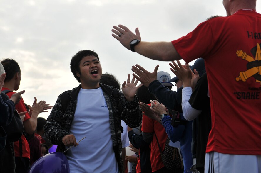 Athletes participating in the 13th annual Kadena Special Olympics arrive as thousands of attendees cheer them on as part of the KSO opening ceremonies on Kadena Air Base, Japan, Nov. 17, 2012. Kadena Special Olympics began in 2000 with approximately 400 athletes and 600 volunteers as an 18th Wing community goodwill initiative to strengthen U.S. - Okinawa relationships. After 13 years, the event has more than tripled in size and participation. (U.S. Air Force photo/Tech. Sgt. Jocelyn Rich)