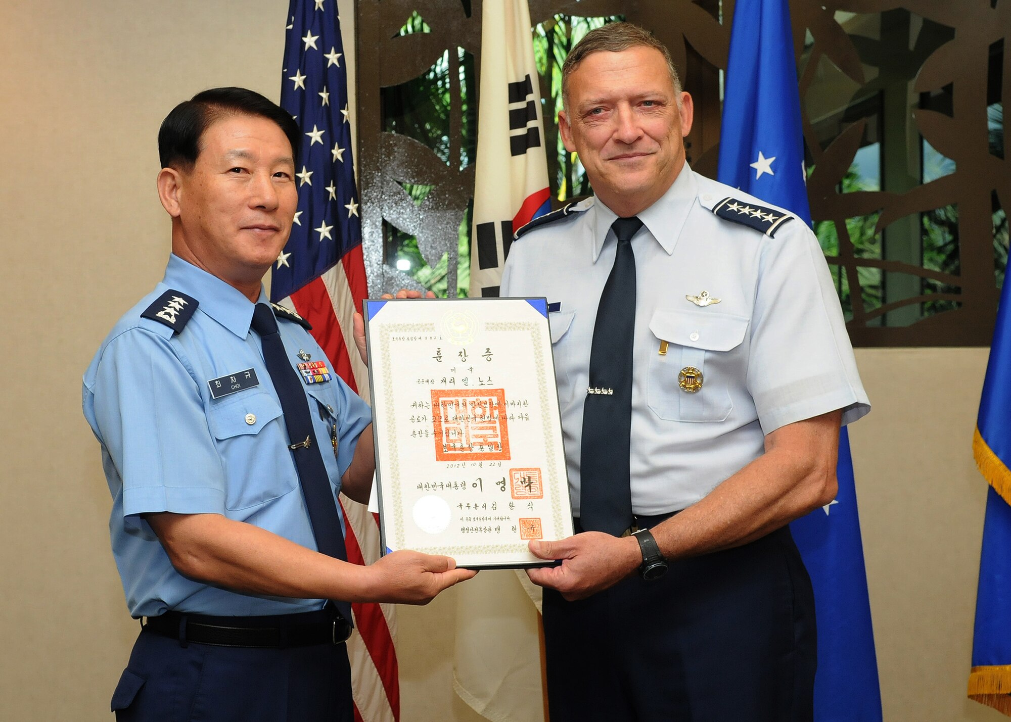 Lt. Gen. Cha-Kyu Choi, Republic of Korea, Air Force Vice Chief of Staff, presents retired Gen. Gary North, former Pacific Air Forces commander, with the National Security Merit Tongil certificate at the DePonte Suite, Headquarters PACAF, Joint Base Pearl Harbor-Hickam, Hawaii, Nov. 9, 2012. North was presented the medal for his contribution in promoting military cooperation between the ROKAF and the USAF. (U.S. Air Force photo/David Underwood/Released)