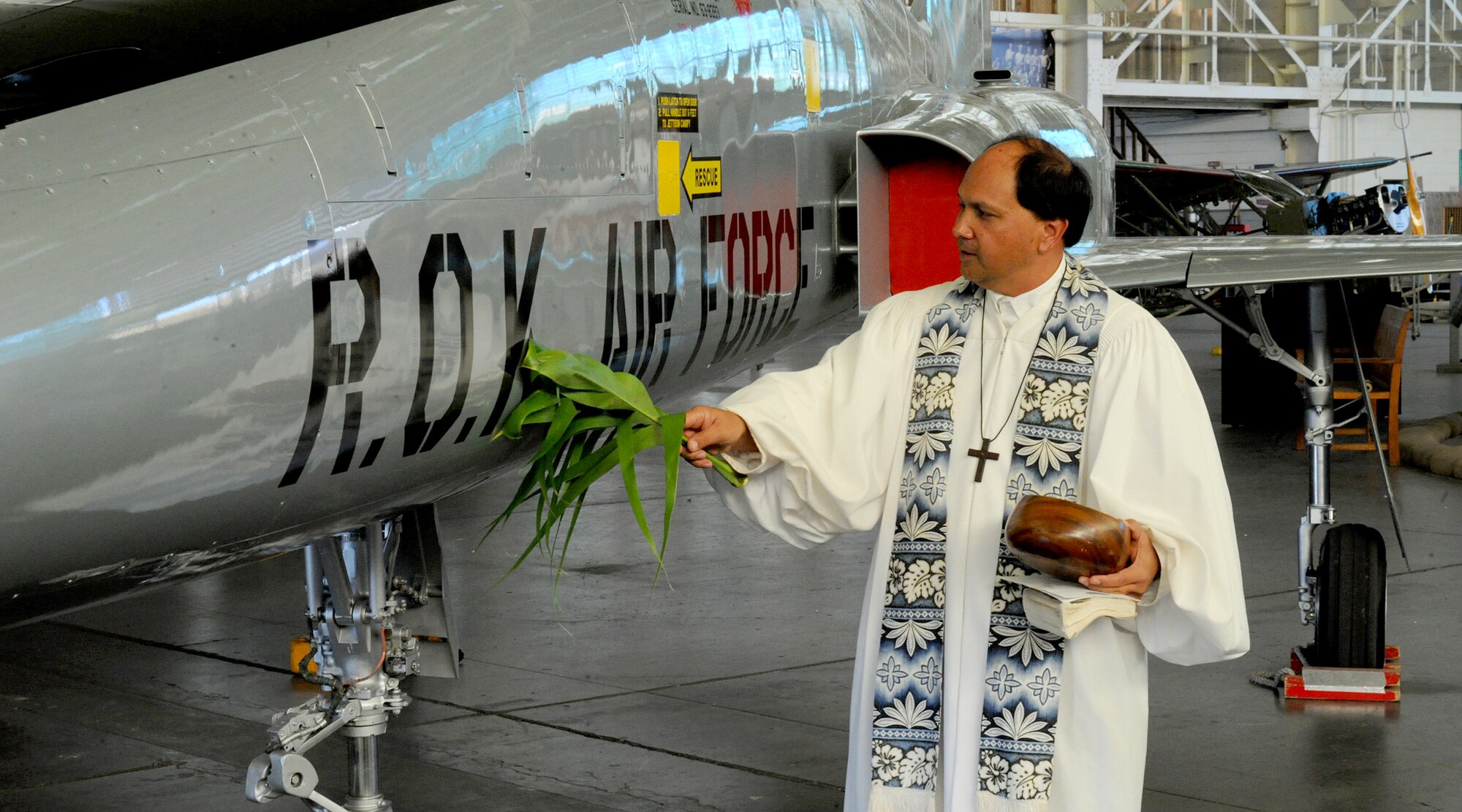 Kahu Kordell Kekoa blesses a Republic of Korea Air Force F-5A Freedom Fighter with ti leaves and Hawaiian water during the F-5A dedication ceremony at the Pacific Aviation Museum, Hawaii, Nov. 12, 2012. The aircraft was dedicated to Gen. Kim Too Man, a legendary figure in the ROKAF. This aircraft honors the rich airpower of the Pacific, and serves as a reminder that ROKAF and American Airmen have served side by side for over 60 years. (U.S. Air Force photo/Tech Sgt. Jerome S. Tayborn/Released) 