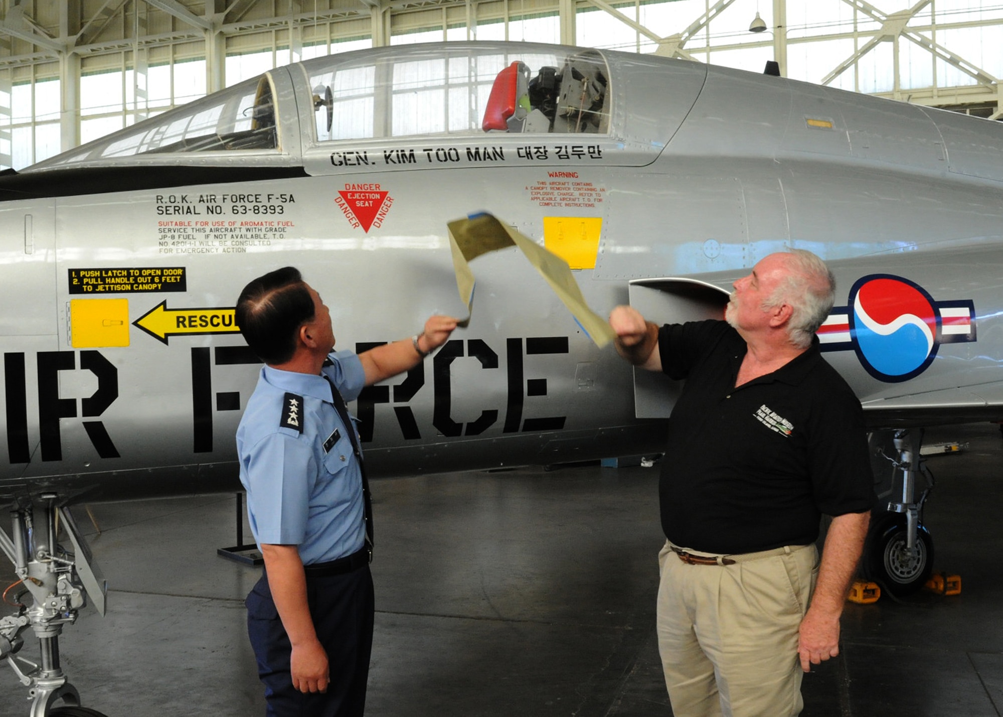 Lt. Gen. Cha-Kyu Choi, Republic of Korea, Air Force Vice Chief of Staff, and Burl Burlingame, Pacific Aviation Museum, curator, unveil a ROKAF F-5A Freedom Fighter dedicated to Gen. Kim Too Man, a legendary figure in the ROKAF, at Pacific Aviation Museum, Ford Island, Hawaii, Nov. 12, 2012.  The aircraft joins the museum’s growing collection of more than 35 historic aircraft.  (U.S. Air Force photo/Tech Sgt. Jerome S. Tayborn/Released)
