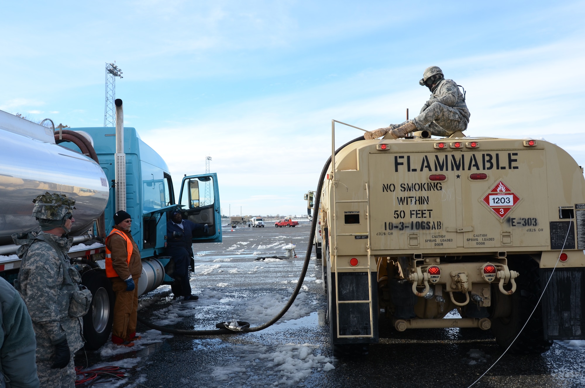 Sgt. Rockieve Givian (top right), petroleum specialist, Company E, 310 Task Force Phoenix, Fort Drum, N.Y, fills his fuel truck at the fueling point, Nov. 8, Fort Dix, N.J. Soldiers are working along Federal Emergency Management Agency contractors who bring fuel from other parts of the nation in support of Hurricane Sandy. The fuel is later distributed at coordinated points in New Jersey and New York. (Photo by Sgt. Ferdinand Detres Jr/Released)