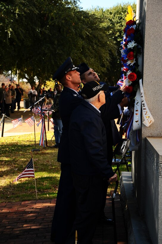 Joel McAdams, WWII veteran, Col. Jim Sears, 14th Flying Training Wing Commander and Airman 1st Class Jason Laufer, 14th Civil Engineer Squadron lay a wreath upon an armed forces memorial at the Lowndes County Courthouse during a Veterans Day ceremony Nov. 10.  Columbus Air Force Base and the local community held an annual parade and ceremony in downtown Columbus to honor past and present veterans.  (U.S. Air Force Photo/Senior Airman Chase Hedrick)