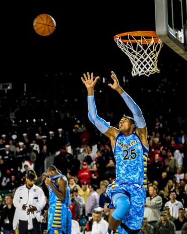 Service members from Joint Base Charleston watch from the stands as a member of the Marquette University men’s basketball team warms up before the start of the match between the Ohio State men’s basketball team during the 2nd Annual Carrier Classic team Nov. 9, 2012 in Charleston, S.C.. The men's and women's basketball teams from Ohio State University, as well as the Notre Dame women's team and Marquette University men's team were scheduled to play. The men’s game between Marquette University and Ohio State was canceled due to moisture on the court. (U.S. Air Force photo/ Senior Airman Dennis Sloan)