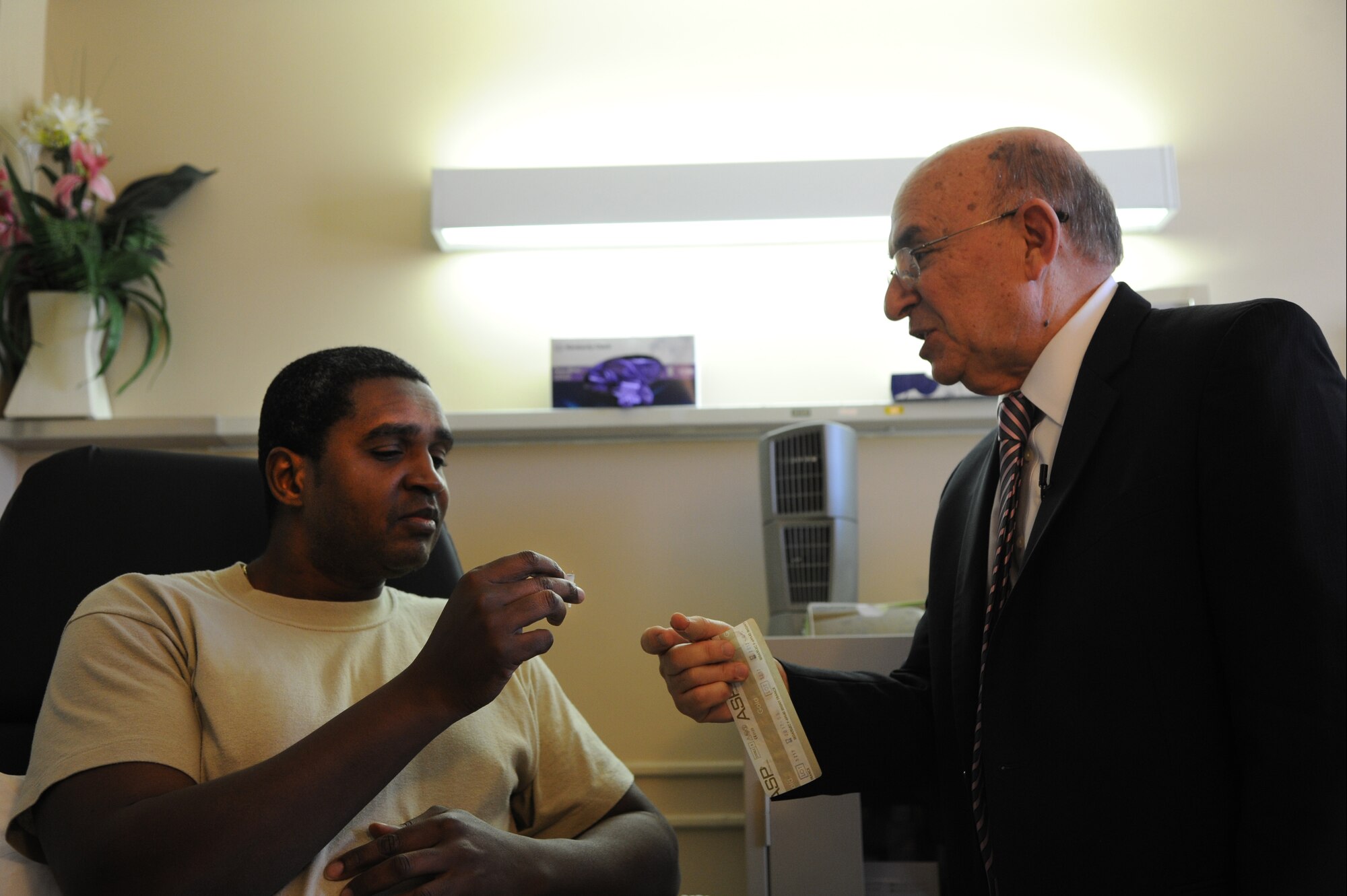 JOINT BASE ANDREWS, Md. - Dr. Richard Niemtzow, 779 Medical Operations Squadron chief of acupuncture, introduces patient Master Sgt. Elie Bellevue to the needles used in Battle Field Acupuncture at Malcolm Grow Medical Clinic, Nov. 16, 2012. In 2001, Niemtzow was intorduced to a new, smaller needle used by a French physicial for acupuncture treatment on ears. (U.S. Air Force photo/Airman 1st Class Aaron Stout)