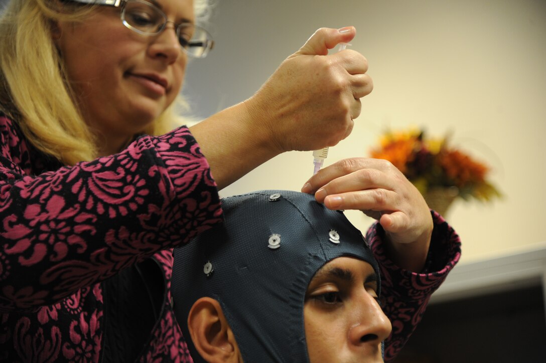 JOINT BASE ANDREWS, Md. - Dr. Beth Davis,779 Medical Operations Squadron deployment behavioral health psychiatrist, injects a conductive gel into a specialized piece of equipment at Malcolm Grow Medical Clinic, Nov. 16, 2012. The gel is needed for the sensors to pick up the impulses from the patients brain. (U.S. Air Force photo/Airman 1st Class Aaron Stout)