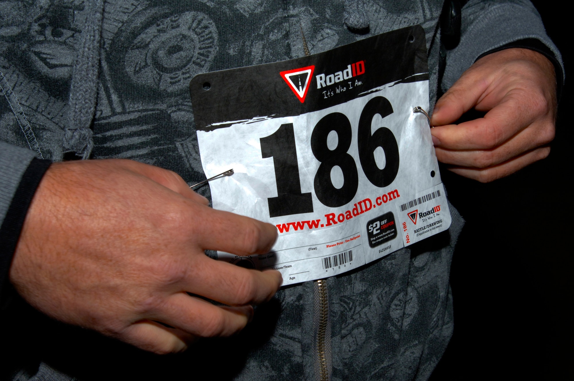 U.S. Air Force Master Sgt. Kelly Moose, 1st Aircraft maintenance squadron first sergeant, pins on his number for the Langley First Sergeants Council 5K Fun Run Walk to benefit Operation Warmheart, at Langley Air Force Base, Va., Nov. 16, 2012. Operation Warmheart supports Langley Airman and their families year round. (U.S. Air Force photo by Airman 1st Class Victoria Taylor/Released)