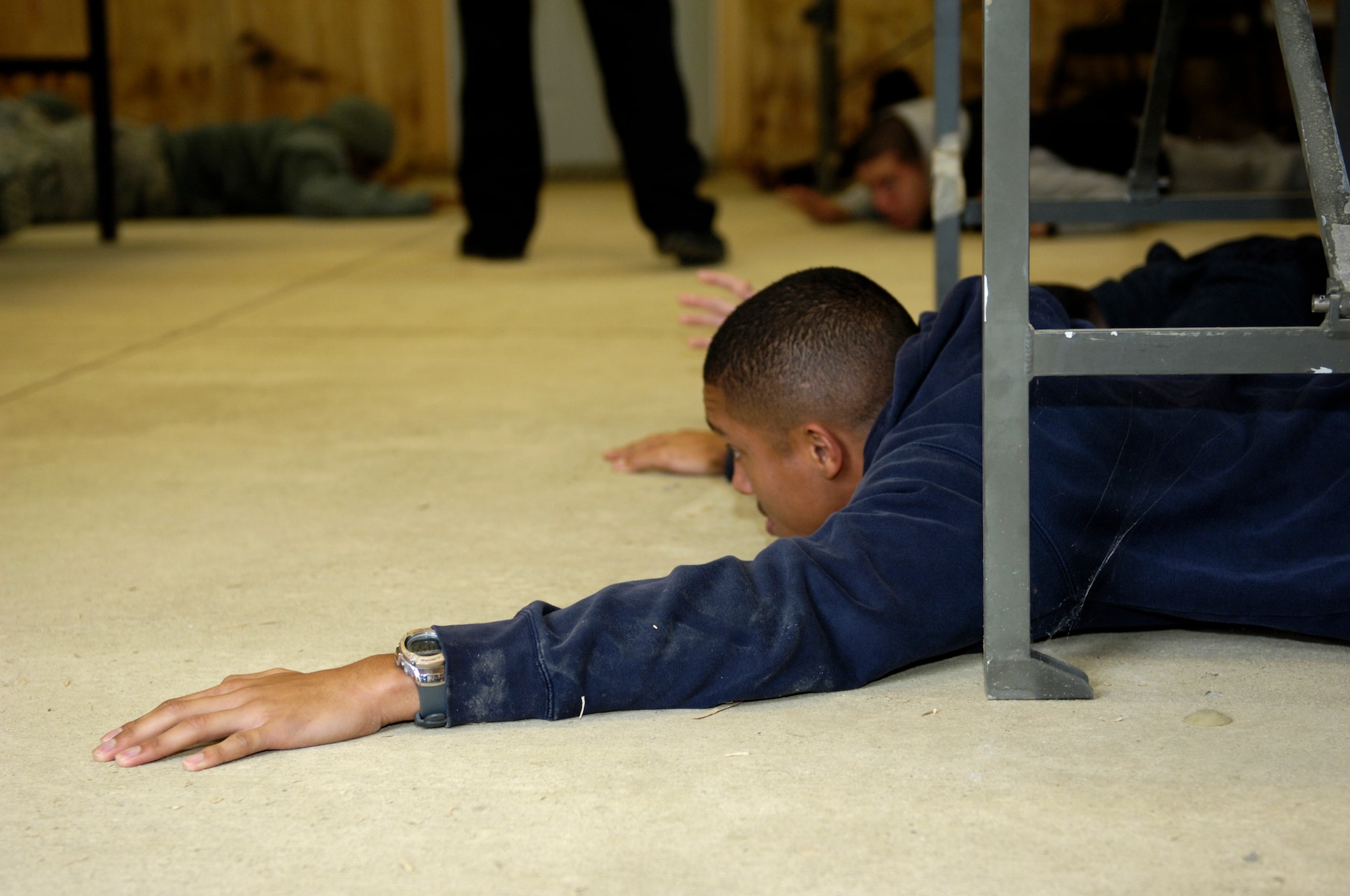 U.S. Air Force Airman 1st Class Dumal Bruce, 27th Intelligence Support Squadron help desk technician, lies on the ground awaiting further instructions from Security Forces at Langley Air Force Base, Va., Nov. 15, 2012. Bruce was a participant in an active shooter exercise, testing the abilities of first responders during extreme scenarios. (U.S. Air Force photo by Airman Kimberly Nagle/Released)