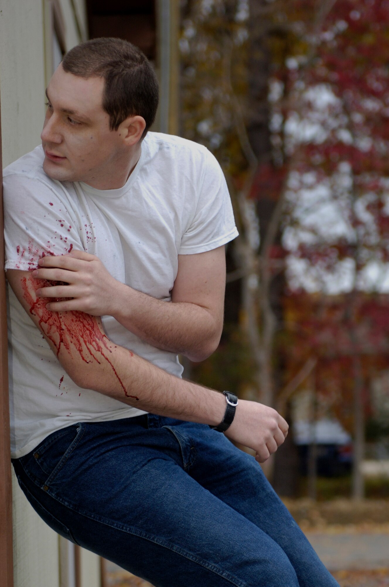 A wounded participant of an active shooter exercise uses a building to shield himself from further harm at Langley Air Force Base, Va., Nov. 15, 2012. The exercise was used to evaluate the first responses of security forces, ambulance services, and the fire department. (U.S. Air Force photo by Airman Kimberly Nagle/Released)
