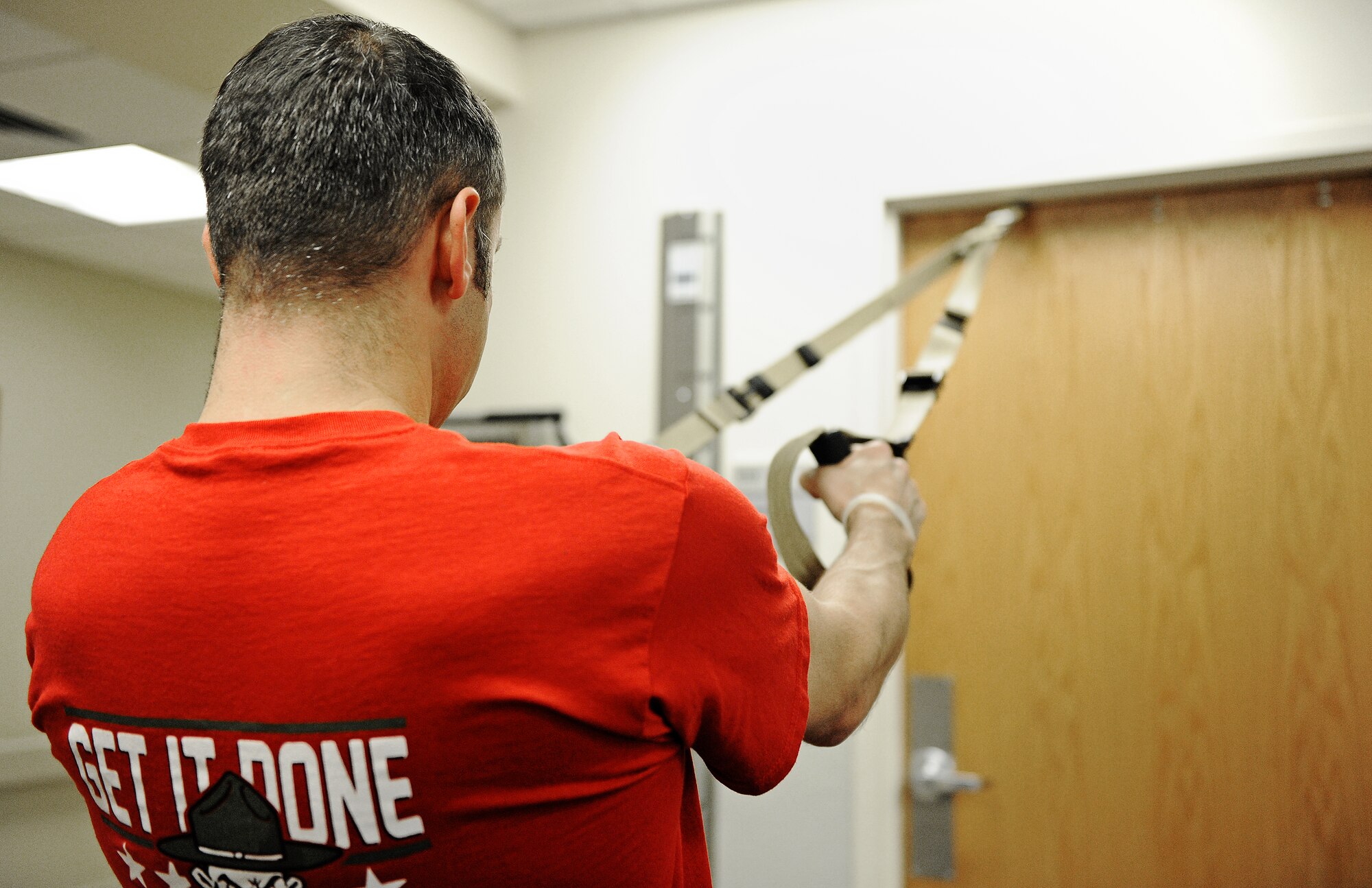 Senior Master Sgt. Darren Dunham, Air Mobility Command inspector general, uses tension straps to work out various muscle groups during his physical therapy session Nov. 13 at Scott Air Force Base, Ill. The physical therapy clinic houses a wide variety of equipment for patients to use in order to rehabilitate their injuries. (U.S. Air Force photo/Airman Kris Lynch)