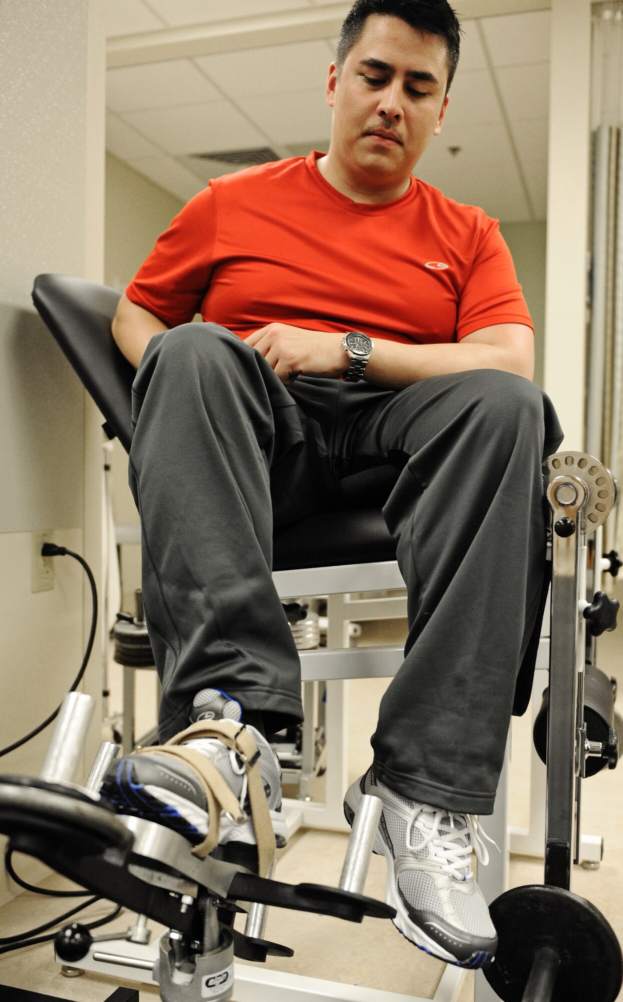 Capt. Mike Hall, Air Force Integration Center network systems engineer, works on his lower leg injury during his physical therapy session Nov. 13 at Scott Air Force Base, Ill. The equipment attached to his foot has weights attached which strengthen his calf muscle every time he flexes and extends his foot. (U.S. Air Force photo/Airman Kris Lynch)
