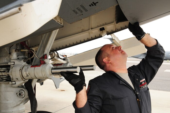 Tech. Sgt. Joshua Drakos, 437th Aircraft Maintenance Squadron crew chief, performs a preventative maintenance check on the landing gear of a C-17 Nov. 14, 2012, at Joint Base Charleston - Air Base, S.C. Drakos was awarded the identifier of Dedicated Crew Chief during a ceremony in June 2012.  A DCC is typically a senior-experienced crew chief who is assigned to one particular aircraft, but assists and mentors other crew chiefs on the flightline. (U.S. Air Force photo/Tech. Sgt. Vernon Cunningham)