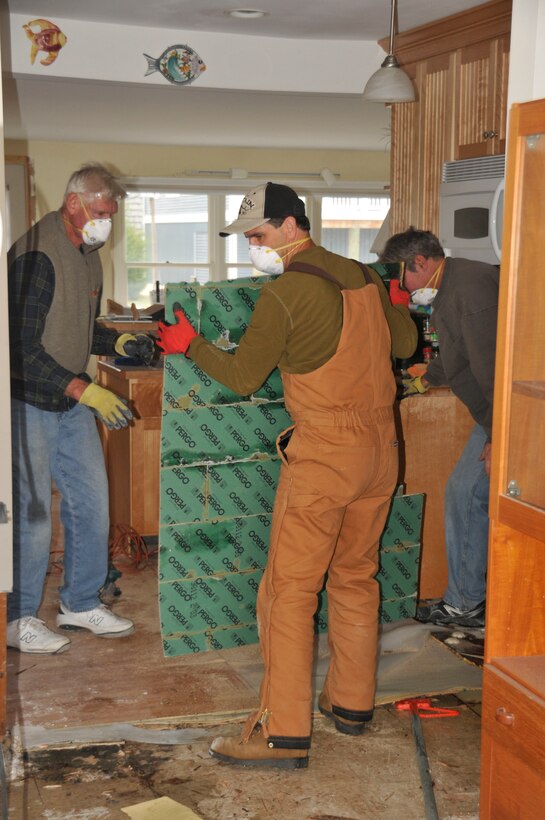 Dan Marren, Arnold Engineering Development Complex’s Tunnel 9 director, helps homeowner Ed Chase (left) and his son, Todd, clean up Ed’s house in South Bethany, Del., following Super Storm Sandy, which flooded the first floor of his home.